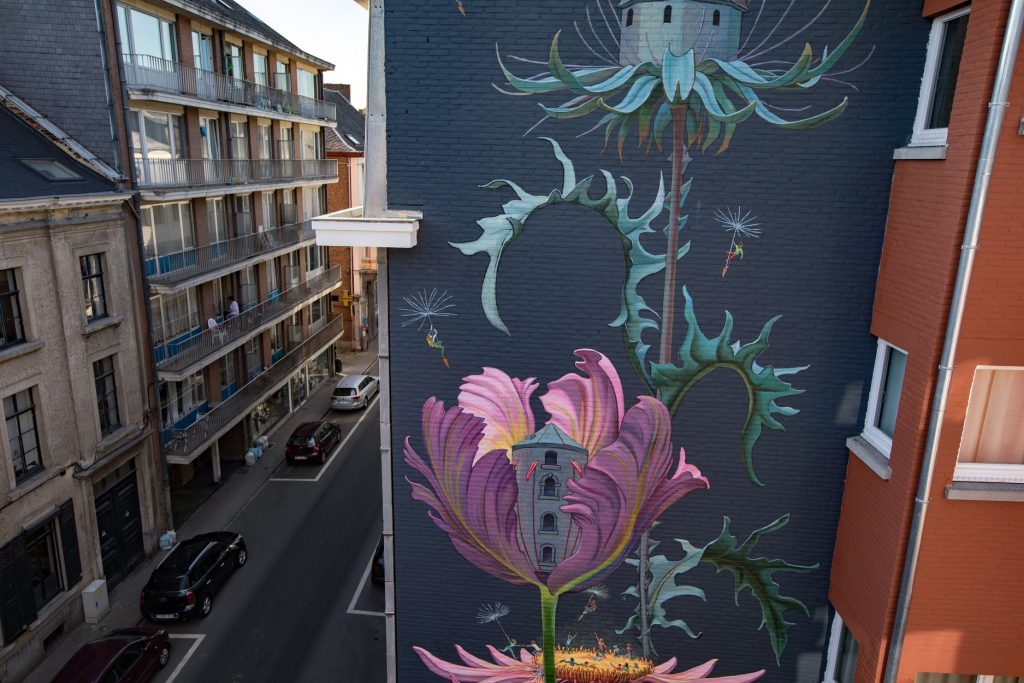 Grande fresque de plantes sauvages et de fleurs géantes sur le pignon d'un immeuble à Namur
